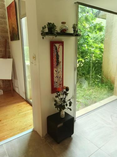 a room with a door with a picture and a vase with flowers at Charming house in Finistère in Coray