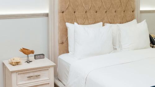 a bedroom with a bed with white pillows at voco Royalty Puebla Downtown by IHG in Puebla