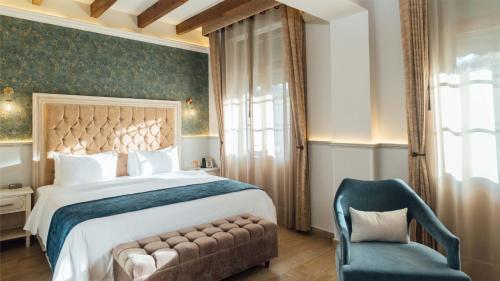 a bedroom with a large bed and a chair at voco Royalty Puebla Downtown by IHG in Puebla
