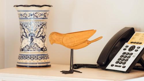 a telephone and a vase and a bird on a shelf at voco Royalty Puebla Downtown by IHG in Puebla