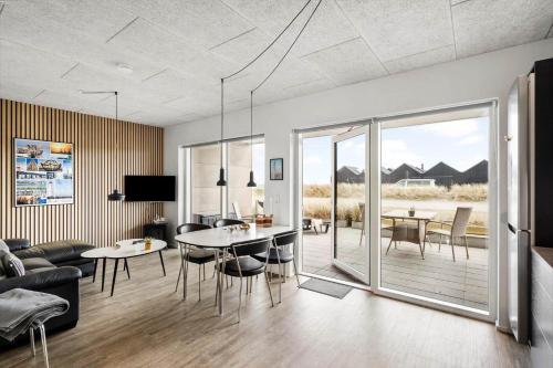a living room with a table and chairs and a couch at 9928-Hvide-Sande-Langsand-86 in Hvide Sande