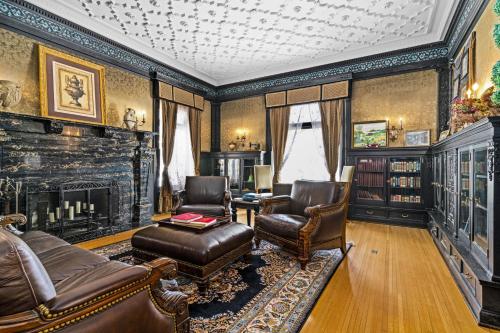 a living room with a couch and chairs and a fireplace at Historic Cotton Mansion by Heirloom Boutique Collection in Duluth
