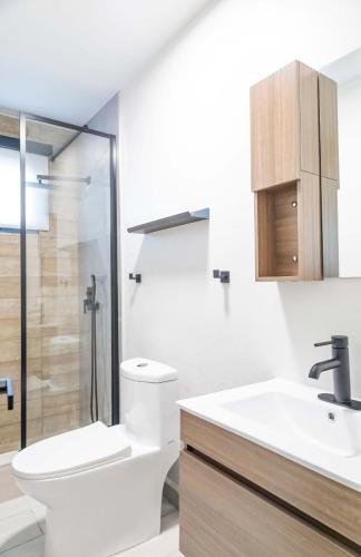 a bathroom with a toilet and a sink and a shower at AQUA Villas Del Mar Apt 7 - 1BR Coastal Getaway by the Beach in Dorado