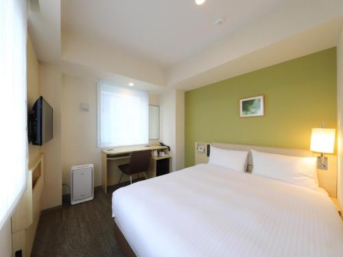 a hotel room with a large white bed and a desk at Smile Hotel Shinagawa Sengakuji Ekimae - Vacation STAY 67645v in Tokyo