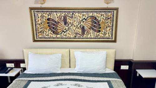 a bedroom with a bed with a painting above it at EPHESUS CENTRUM in Selcuk