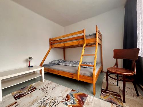 a bedroom with a bunk bed and a desk and a chair at Brána do České Kanady in Český Rudolec