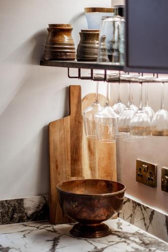 a bowl on a counter with glasses on a shelf at Green Maison Westfield in London