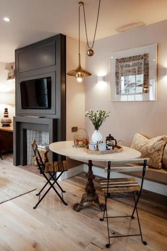 a living room with a table and a fireplace at Green Maison Westfield in London