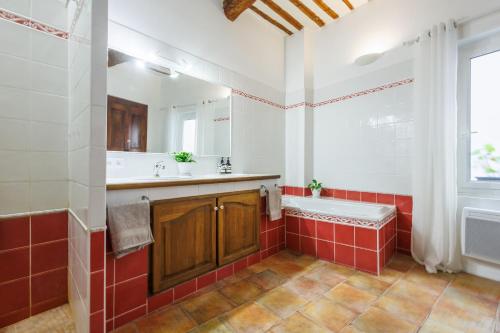 a bathroom with a tub and a sink and a bath tub at Provence Village House 84 in Beaumes-de-Venise