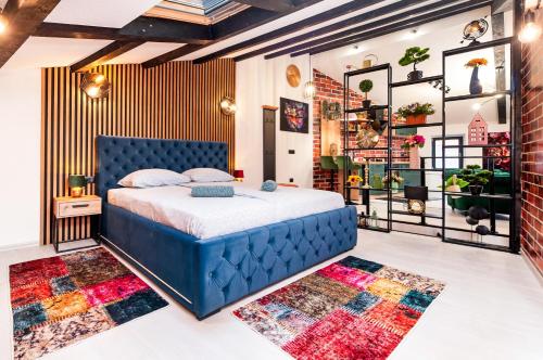 a bedroom with a blue bed in a room with rugs at Apartman Rio in Rovinj