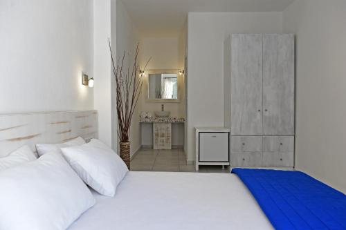 a bedroom with a large white bed and a sink at Porto Naoussa in Naousa