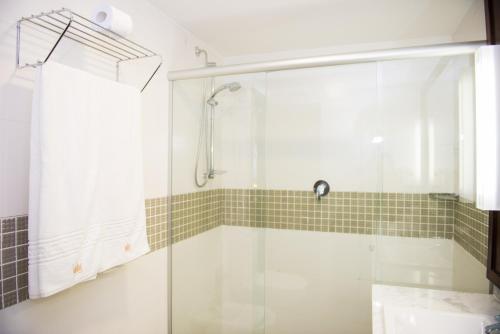 a shower with a glass door in a bathroom at Royal Atlântica Macaé Hotel in Macaé