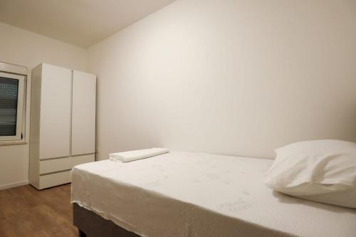 a white bedroom with a bed and a window at Apartman Beljo in Neum
