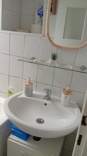 a white sink in a bathroom with a mirror at Kleine Möwe in Wilhelmshaven