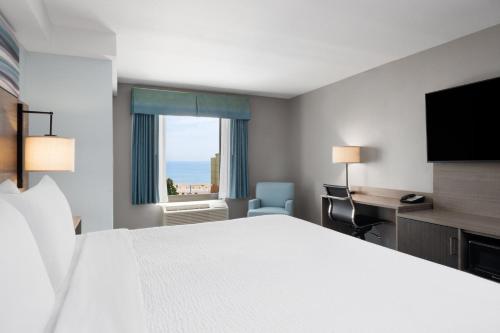 a hotel room with a bed and a desk and a window at Garner Hotel Virginia Beach North by IHG in Virginia Beach