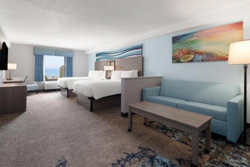 a hotel room with a bed and a couch at Garner Hotel Virginia Beach North by IHG in Virginia Beach