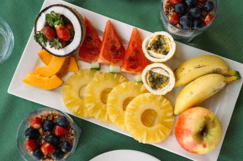 une assiette blanche avec des fruits sur une table verte dans l'établissement The Soul Zanzibar Beach Hotel & Spa, à Pwani Mchangani Mdogo