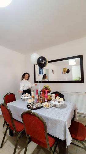 a woman sitting at a table with food on it at ANK - HOME i PRESIDENT - NIK in Telcişor