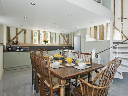 a kitchen with a wooden table and chairs at Tatters Barn in Bradwell