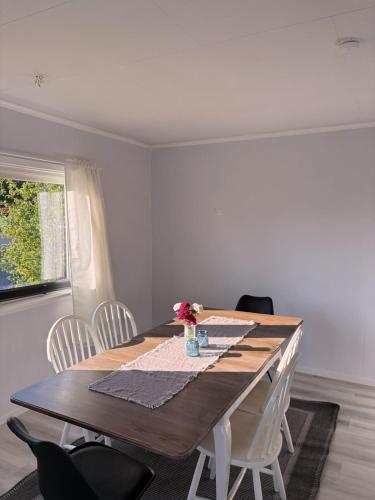 a dining room table with white chairs and a wooden table at House in Nordfjord, with 4 bedrooms in Nordfjordeid