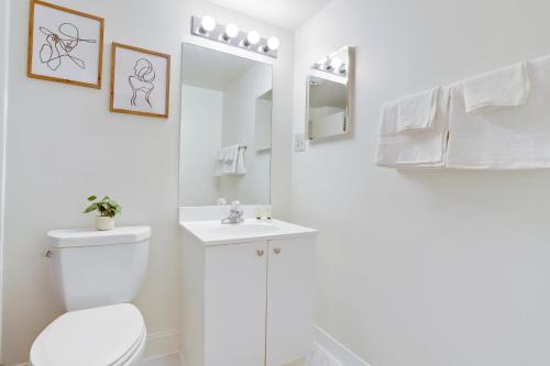 une salle de bains blanche avec toilettes et lavabo dans l'établissement Bright Apt - Gym Access & Great Location, à Arlington