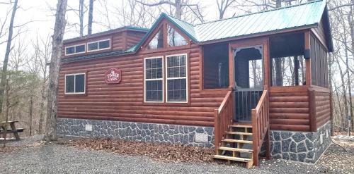 a cabin in the woods with a porch and a door at The Timber Cabin in Marshall