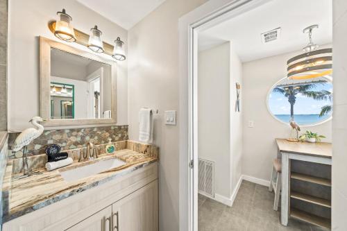 a bathroom with a sink and a mirror at The Banana River Resort in Cocoa Beach