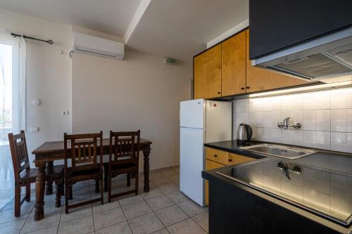 a kitchen with a table and a sink and a refrigerator at Mythos Suites-Apollo apartment in Methoni