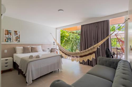 Un dormitorio con una cama y una hamaca. en Casa no Lago, en Ananindeua