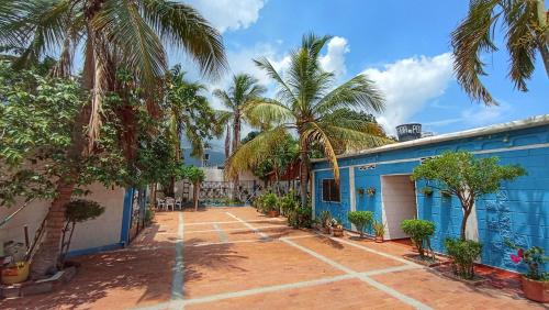 a blue building with palm trees in front of it at Monkey man, Beach House in Santa Marta