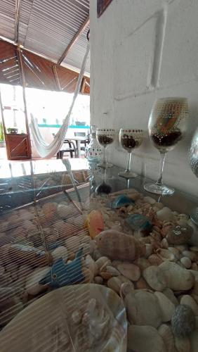two glasses of wine sitting on a table with rocks at Monkey man, Beach House in Santa Marta