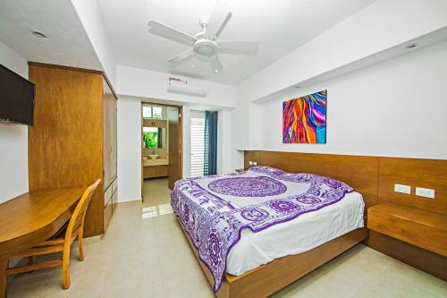 a bedroom with a bed and a ceiling fan at Casa CAMPANA, Privada, Piscina Privada, 3 Cuadras Malecón in Cozumel