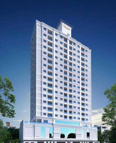 a tall white building with a sign on top at Apartamento temporada - Meia Praia in Itapema