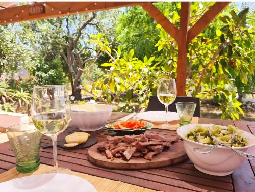 a table with a plate of food and glasses of wine at Casa do Avô António in Bensafrim