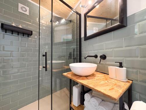 リバデオにあるApartamentos Ribadeoの洗面台とガラスのシャワーを備えたバスルーム