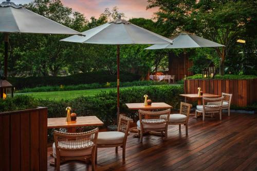 a patio with tables and chairs and umbrellas at Bvlgari Hotel Beijing in Beijing