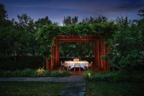 a dinner table in a pavilion in a garden at night at Bvlgari Hotel Beijing in Beijing