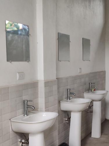 a bathroom with two sinks and two mirrors at Mochileros de Nicaragua in Moyogalpa
