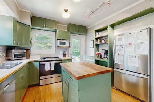 a kitchen with green cabinets and a wooden counter top at Balsam House in Baraboo