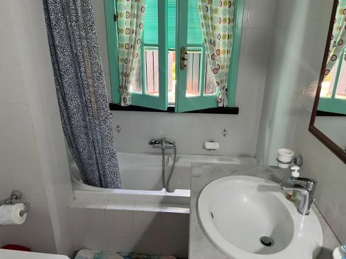 a bathroom with a sink and a toilet and a window at Casa Ariel in Avola