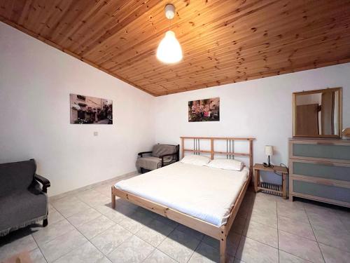 a bedroom with a bed and a wooden ceiling at Lucky Farm House in Potamiá
