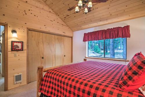 a bedroom with a bed with a red checkered blanket at Game Room and Deck Pet-Friendly Camp Connell Cabin in Camp Connell