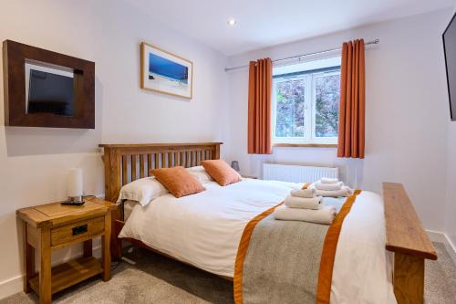 a bedroom with a bed and a tv on the wall at Premium 2 Bed Apt 1st floor sleeps 4 adults in Oban town in Oban