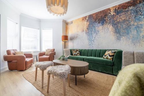 a living room with a green couch and chairs at Large house in centre of Portrush with free parking x 2 cars in Portrush