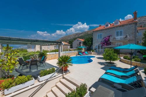 a patio with chairs and a pool and a building at Villa Ida in Dubrovnik