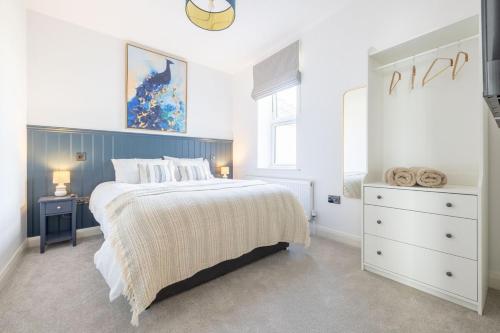 a bedroom with a large bed and a dresser at Large house in centre of Portrush with free parking x 2 cars in Portrush