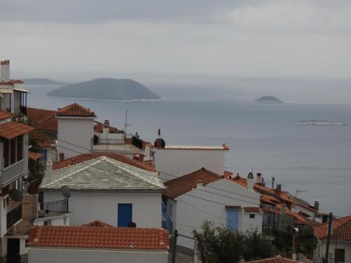 a view of roofs of houses and the ocean at Dimitra's house in Glóssa