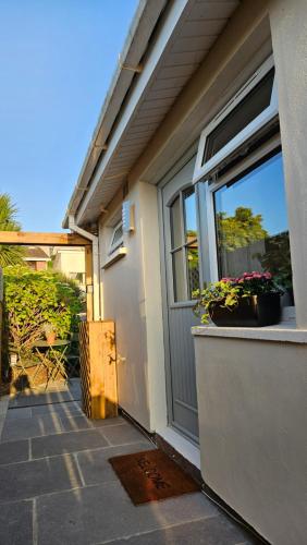 a house with a window with flowers in it at Induli Holywood - Private Luxury Double Room near Belfast in Cultra