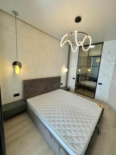 a bedroom with a bed and a chandelier at Sea view apartments in Odesa