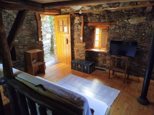 a living room with a couch and a television at Casa da Avó Celta in Lousã
